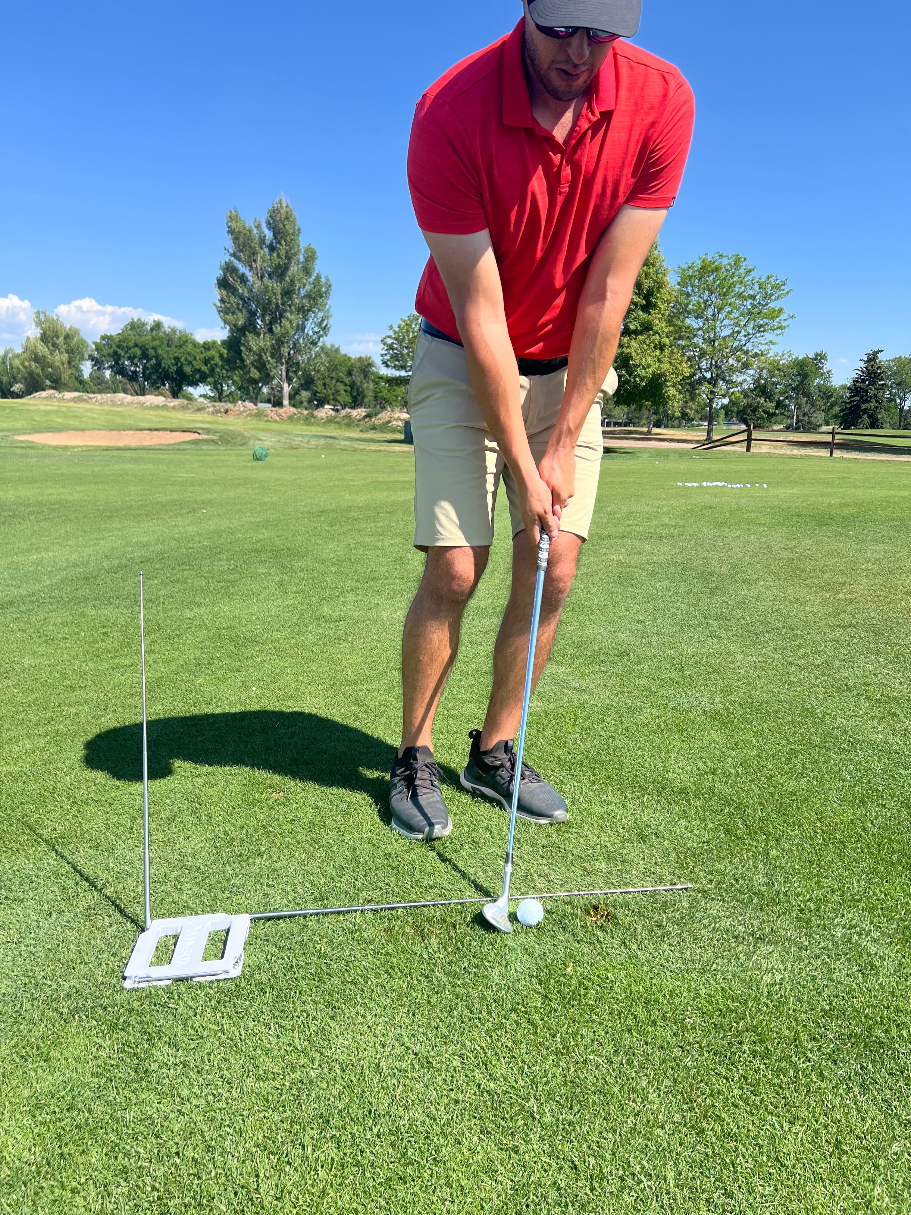 Golfer setting up AimBox alignment rods before practice