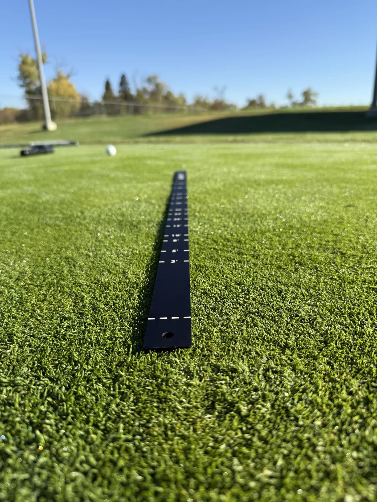 AimPutt distance side laid on a putting green, low angle